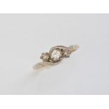 A three-stone diamond ring, the central brilliant-cut stone of approximately .10ct, illusion-set and