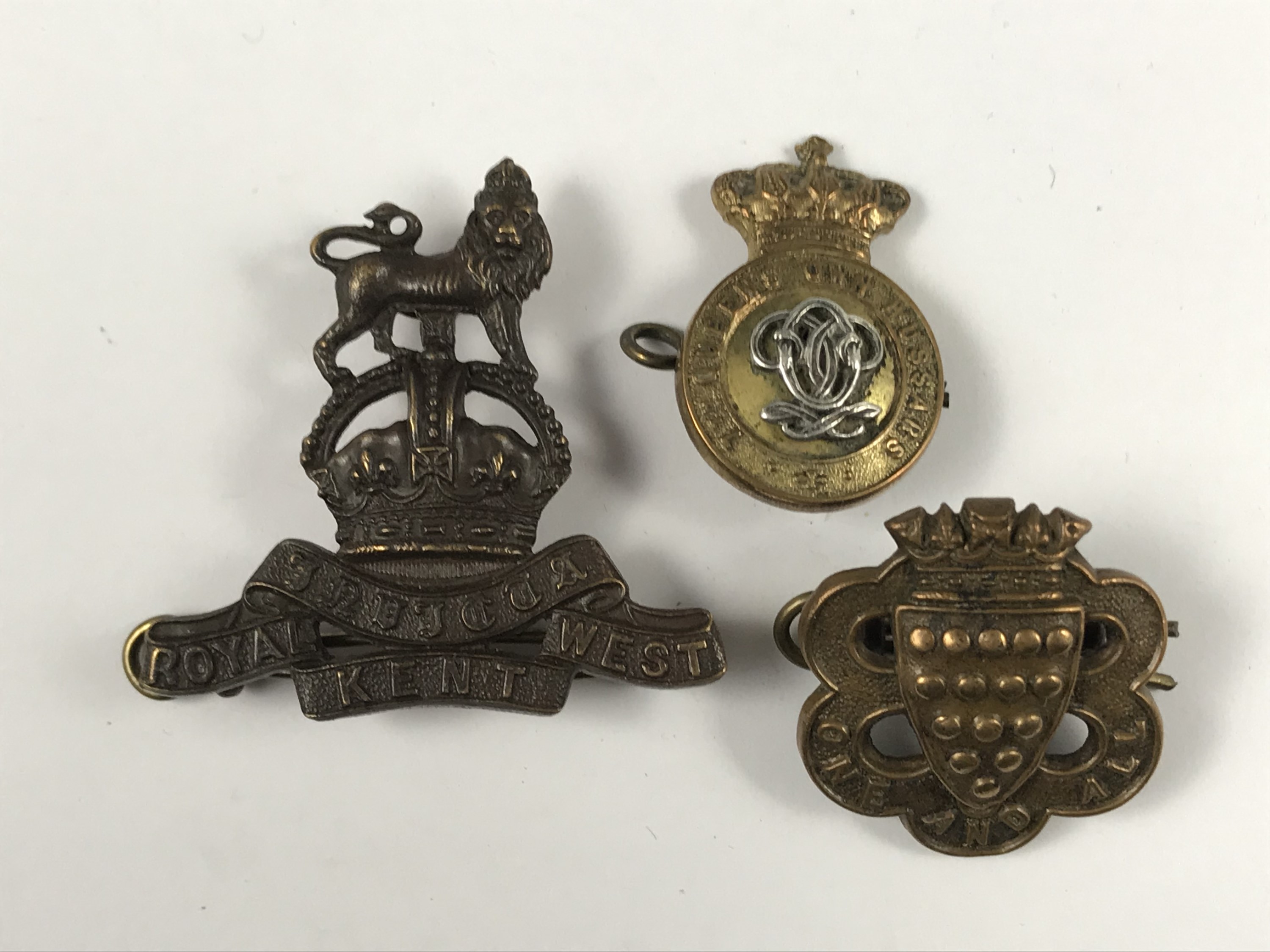 A Royal West Kent Regiment officer's Service Dress cap badge, together with a Victorian 7th Queen'