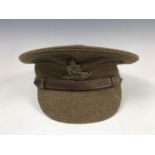A British Army serge peaked cap, of other ranks' quality, bearing Royal Artillery cap badge,