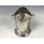 An Edwardian silver Arts and Crafts syphon / bottle stand, having planished decoration and an
