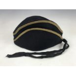 A late 19th Century military torin / cap, in blue melton cloth with yellow cotton braid and silk