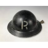 A Second World War Civil Defense helmet bearing the initial R in white