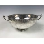 A George V Arts and Crafts planished silver bowl, having an open Celtic influenced interlaced-