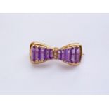 A 9ct gold, diamond and amethyst brooch modelled in the form of a bow, in an openwork arrangement,