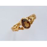 An Edwardian 18ct gold and citrine dress ring, having a central oval-cut stone, rub-set and