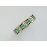 An early 20th Century high-carat white-metal, emerald and diamond half-hoop eternity ring, having