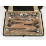 An early George V silver handled manicure set, having raised decoration in the form of floral