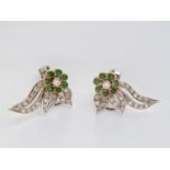 A pair of mid-20th Century emerald and diamond ear clips, in a writhen floral arrangement, each