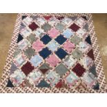 A 19th Century patchwork quilt, in a diamond pattern of predominantly red, pink and blue printed