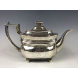 A George III silver tea pot, having bands of wriggle-work and engraved decoration, above a wreath-