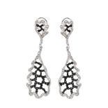 Pendientes largos en oro blanco con centro calado de diamantes blancos y negros talla brillante.