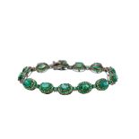 Pulsera en oro pavonado con rosetones de esmeraldas talla oval orladas por granates verdes. Peso