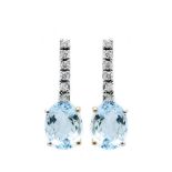 Pendientes en oro blanco con barrita articulada de diamantes talla brillante rematada por aguamarina