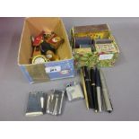 Box containing a quantity of various items including miniature mantel clocks, match boxes,