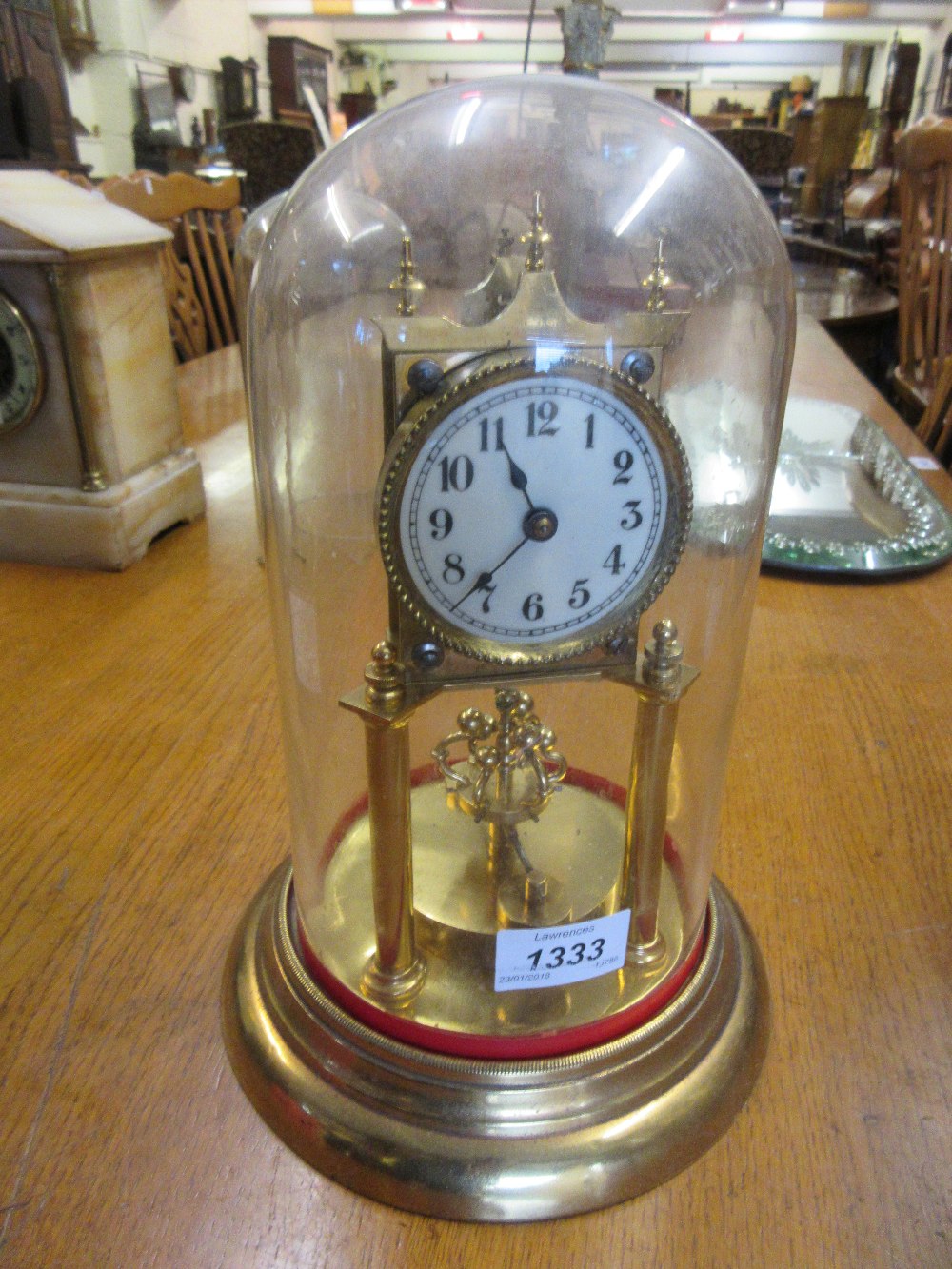 Brass three hundred day clock beneath a glass display dome