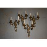 Set of four rococo style gilt brass two branch wall lights