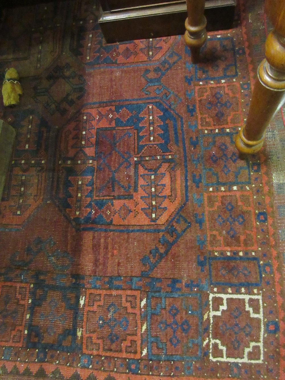 Early 20th Century Afghan rug having three rows of repeating medallions on a red ground with