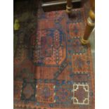 Early 20th Century Afghan rug having three rows of repeating medallions on a red ground with