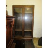 20th Century oak bookcase having two glazed doors enclosing adjustable shelves above a further two