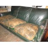 Early 20th Century green leather upholstered three seat sofa on bun feet (at fault)