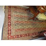 Indo Persian rug woven with a stripe and boteh design in shades of red, green,