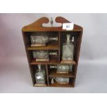 Group of glass ships in bottles with display shelf (one at fault)