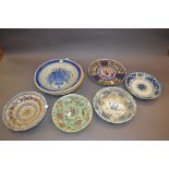 Three Continental pottery wall plates together with a quantity of other decorative plates