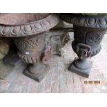 Pair of cast iron pedestal two handled garden urns on square bases, 8.