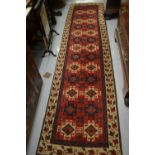 Turkish runner with all-over hooked medallion design on a red ground with borders