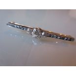 Early 20th Century diamond bar brooch, the large central old cut oval stone flanked by two smaller,
