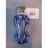 Blue overlay cut glass perfume bottle with ornate hinged white metal top,