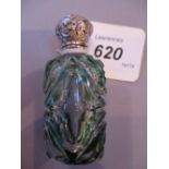 Green overlay glass perfume bottle with ornate white metal stopper,