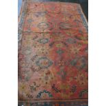 Turkey runner with an all-over stylised floral design on brick red field,