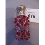 Victorian red overlay perfume bottle with ornate white metal top and stopper,