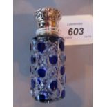 Blue overlay hobnail cut glass cylindrical perfume bottle with ornate white metal screw top,