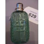 Pale green cut glass perfume bottle with plain hinged white metal top and stopper,