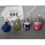 Group of four various miniature perfume bottles in blue glass, yellow glass,