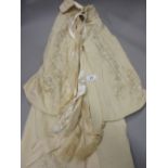 Box containing a child's embroidered Victorian flannel cloak,