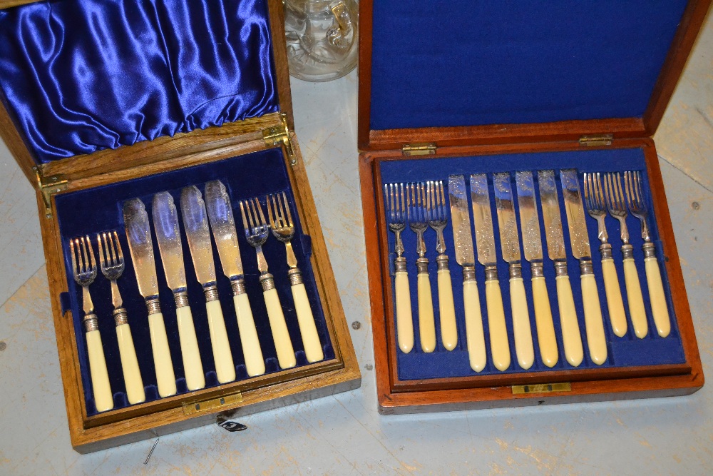 Mahogany cased set of twelve silver plated dessert knives and forks and an oak cased set of eight