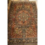 Tabriz rug with a medallion and all-over stylised floral design in shades of brick red and blue,