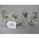 Similar lot of four clear glass perfume bottles with white metal mounts,