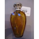 Amber faceted cut glass perfume bottle of ovoid design with ornate white metal top and stopper,