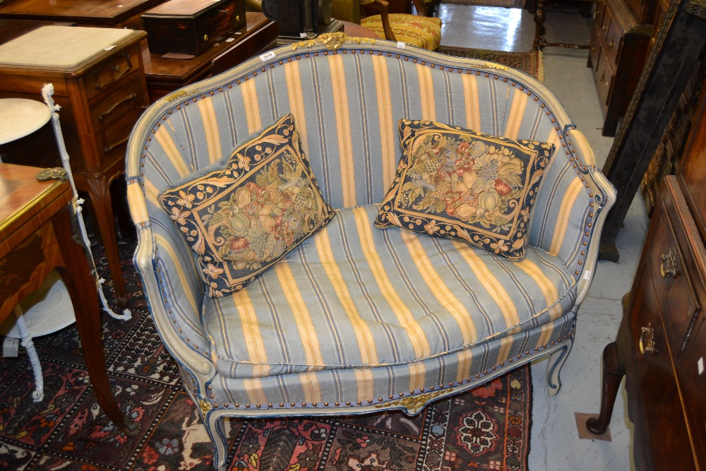 Small reproduction painted two seater sofa in French style with a striped fabric upholstery
