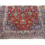 Kashan rug with a centre medallion and all-over floral design with multiple borders on a burgundy