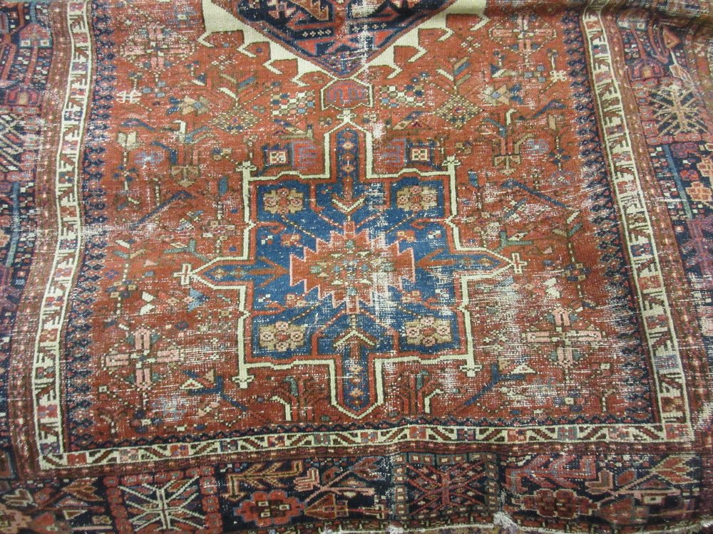 Karaja rug having a row of three hooked medallions and multiple borders on a rust and blue ground,