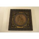 Italian circular carved walnut panel of a seated cherub holding an arrow in a square frame with