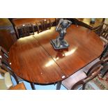 George III mahogany D-end dining table raised on square moulded supports with brass casters,