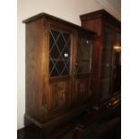 Small reproduction oak bookcase with leaded glass doors and a similar low corner cupboard