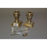 Pair of Birmingham silver candlesticks on square bases, shaped oval silver inkwell (lacking glass),