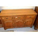 Reproduction oak sideboard with three drawers and two shaped panel doors